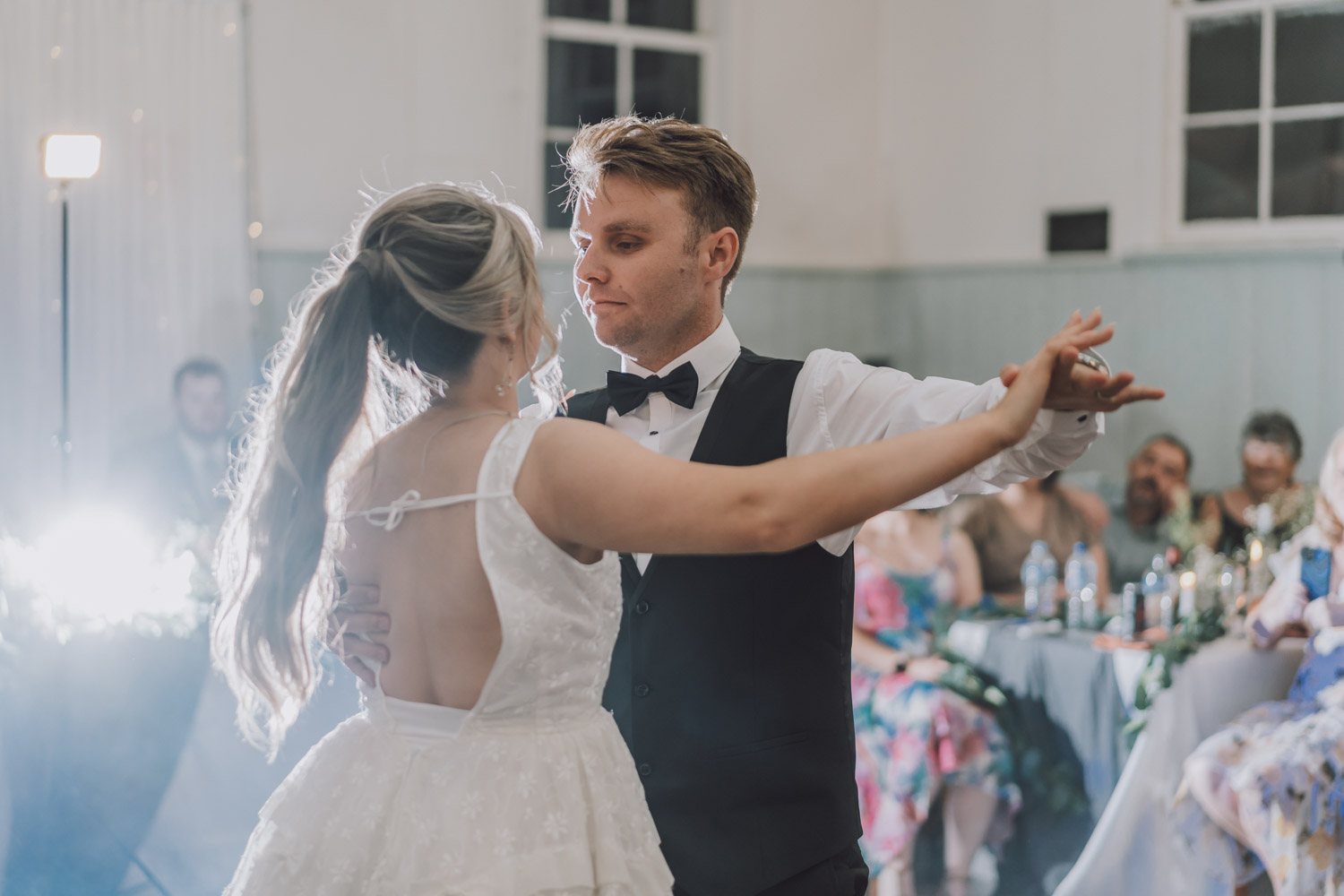 A bride and groom engaged in their first dance in a well-lit Melbourne venue, illustrating a magical moment perfect for a wedding photoshoot in Melbourne. Photo by LaterStory