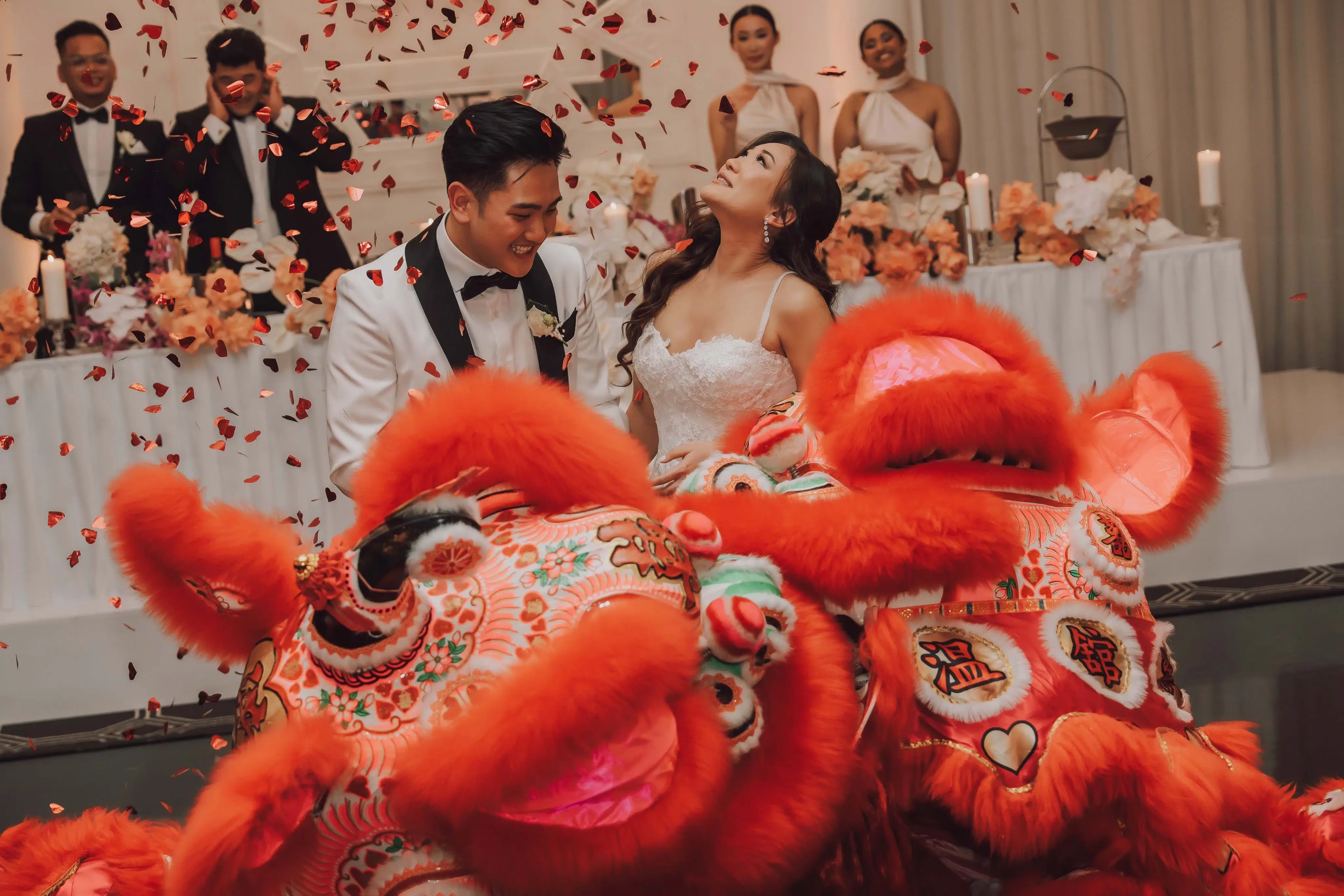 Wedding photography melbourne.A radiant bride and groom in Melbourne enjoying a Chinese lion dance at their wedding, symbolizing luck and happiness.